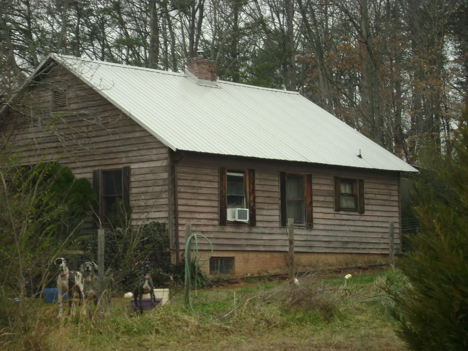 White metal roof on an old wood sided farmhouse, from a Metal Roof Installation job in Daleville
